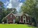 Charming two-story brick home with a well-manicured lawn and mature trees at 1464 Chatsworth Trace, Lawrenceville, GA 30044