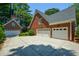Three-car garage with a basketball hoop and a long paved driveway at 1464 Chatsworth Trace, Lawrenceville, GA 30044