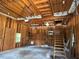 Unfinished garage space features exposed beams, lighting and stairs leading to attic at 1464 Chatsworth Trace, Lawrenceville, GA 30044