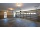 A spacious three car garage interior with neutral paint, shuttered windows, and concrete flooring at 1464 Chatsworth Trace, Lawrenceville, GA 30044