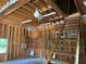 Unfinished garage space features exposed beams and wooden stairs leading to additional storage at 1464 Chatsworth Trace, Lawrenceville, GA 30044