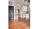 Interior view with hardwood floors, arched doorways, trim details, a built-in desk, and view to the entry and living room at 1464 Chatsworth Trace, Lawrenceville, GA 30044