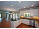 Open kitchen with island, stainless steel appliances, granite counters and hardwood flooring flowing into the living space at 1464 Chatsworth Trace, Lawrenceville, GA 30044