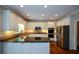 Modern kitchen with white cabinets, granite countertops, stainless steel appliances, and a central island at 1464 Chatsworth Trace, Lawrenceville, GA 30044