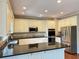 Spacious kitchen with white cabinets, granite countertops, stainless steel appliances, and a large island with sink at 1464 Chatsworth Trace, Lawrenceville, GA 30044