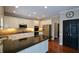Bright kitchen featuring white cabinetry, stainless steel appliances, dark countertops and hardwood flooring at 1464 Chatsworth Trace, Lawrenceville, GA 30044