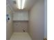 Bright laundry room with overhead storage and shelving at 1464 Chatsworth Trace, Lawrenceville, GA 30044