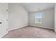 Bedroom with light gray walls and carpet plus a window providing natural light at 162 Aylesbury Blvd, Mcdonough, GA 30252