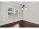 Bright dining room with hardwood floors, chandelier, and large window at 162 Aylesbury Blvd, Mcdonough, GA 30252