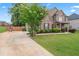 Charming two-story brick home with landscaped yard, lush trees, and driveway at 162 Aylesbury Blvd, Mcdonough, GA 30252