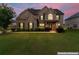 Charming brick two-story home with a well-manicured lawn and inviting curb appeal at twilight at 162 Aylesbury Blvd, Mcdonough, GA 30252