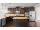 Modern kitchen with stainless steel appliances, dark cabinets, and a granite island at 162 Aylesbury Blvd, Mcdonough, GA 30252