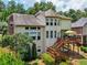 Back exterior of a multi-story home with a spacious deck, large windows, and well-manicured landscaping at 5511 Highland Preserve Dr, Mableton, GA 30126