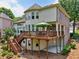 Back exterior of a home with multiple windows, a wooden deck, and a well-maintained yard, perfect for outdoor enjoyment at 5511 Highland Preserve Dr, Mableton, GA 30126