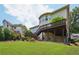 Manicured lawn leads up to the multilevel deck, providing shade and outdoor living space with a green umbrella at 5511 Highland Preserve Dr, Mableton, GA 30126