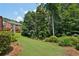 Green lawn with trees and shrubs, bordering neighboring houses, makes for a cozy outdoor space at 5511 Highland Preserve Dr, Mableton, GA 30126