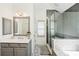 Bathroom featuring double sinks, a stylish, tiled standing shower behind glass and a full-length mirror at 5511 Highland Preserve Dr, Mableton, GA 30126