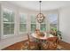 Bright breakfast nook with a wood table, natural light from window and an elegant light fixture at 5511 Highland Preserve Dr, Mableton, GA 30126