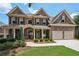 Charming two-story brick home featuring a front porch and manicured landscaping at 5511 Highland Preserve Dr, Mableton, GA 30126