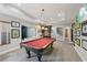 A well-lit game room with a pool table and views of the golf simulator room and wet bar at 5511 Highland Preserve Dr, Mableton, GA 30126