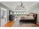 Relax in this main bedroom with hardwood floors, tray ceilings, and a view of the bathroom and backyard at 5511 Highland Preserve Dr, Mableton, GA 30126