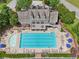 Aerial view of large community swimming pool with lounge chairs and umbrellas, plus a clubhouse in the background at 5511 Highland Preserve Dr, Mableton, GA 30126