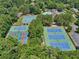 Overhead view of multiple community tennis courts surrounded by lush green trees and a parking lot at 5511 Highland Preserve Dr, Mableton, GA 30126