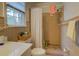 Bathroom featuring a shower with beige tiling, a large window, and beige countertops and cabinets at 1349 Springwood Nw Dr, Conyers, GA 30012