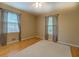 Bedroom with hardwood floors, neutral walls, two windows, a ceiling fan, and light-colored carpet at 1349 Springwood Nw Dr, Conyers, GA 30012
