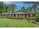 Attractive brick home with covered entryway, black shutters, and lush green landscaping at 1349 Springwood Nw Dr, Conyers, GA 30012