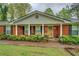 Close-up of a brick home with a covered entryway and well-maintained landscaping at 1349 Springwood Nw Dr, Conyers, GA 30012