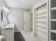 Bright bathroom features double vanity, stylish marble floors, and ample built in shelving at 208 Hembree Park Ter, Roswell, GA 30076