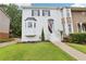 Charming townhome featuring a well-manicured lawn and a classic white-painted brick facade with black shutters at 208 Hembree Park Ter, Roswell, GA 30076