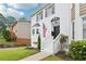 The home features a white painted brick facade with black shutters and a well-manicured lawn at 208 Hembree Park Ter, Roswell, GA 30076