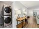 Hallway with stacked washer and dryer and long wooden table at 208 Hembree Park Ter, Roswell, GA 30076