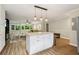 Kitchen island with a granite countertop, white cabinets, and hardwood floors, open to the living room at 208 Hembree Park Ter, Roswell, GA 30076