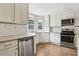 Bright kitchen featuring white cabinets, stainless steel appliances, granite countertops, and modern lighting at 208 Hembree Park Ter, Roswell, GA 30076