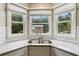 Kitchen sink with a granite countertop and a view of the backyard through a bay window at 208 Hembree Park Ter, Roswell, GA 30076
