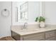 Updated bathroom featuring a marble countertop, gray vanity, and decorative mirror at 2689 Spring Rock Ne Ct, Roswell, GA 30075