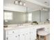 Bathroom vanity featuring a large mirror, white cabinets, and a comfortable stool at 2689 Spring Rock Ne Ct, Roswell, GA 30075