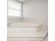 Close-up of a large garden tub with tile surround and a window providing natural light at 2689 Spring Rock Ne Ct, Roswell, GA 30075