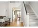 Bright foyer featuring staircase, hardwood floors, bench with pillows, and view into dining room at 2689 Spring Rock Ne Ct, Roswell, GA 30075
