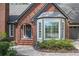 Brick home featuring a covered arched entryway, bay windows and professionally landscaped garden at 2689 Spring Rock Ne Ct, Roswell, GA 30075