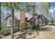Brick home nestled among mature trees with a chimney, bay windows, and a two-car garage at 2689 Spring Rock Ne Ct, Roswell, GA 30075