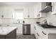 Bright kitchen with white cabinets, stainless appliances, island with quartz countertops, and modern finishes at 2689 Spring Rock Ne Ct, Roswell, GA 30075
