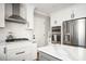 Contemporary kitchen boasts white cabinetry, stainless steel appliances, quartz countertop island and hardwood floors at 2689 Spring Rock Ne Ct, Roswell, GA 30075