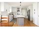 Spacious kitchen featuring island with quartz countertop, stainless appliances, white cabinets, and hardwood floors at 2689 Spring Rock Ne Ct, Roswell, GA 30075