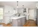 Beautiful kitchen featuring gray island, white cabinets, stainless hood, and hardwood floors at 2689 Spring Rock Ne Ct, Roswell, GA 30075