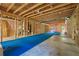 Unfinished basement, framed, with blue matting and exposed ceiling beams at 3405 Camellia Ln, Suwanee, GA 30024