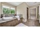 Elegant bathroom with a soaking tub, tile surround, and natural light at 3405 Camellia Ln, Suwanee, GA 30024